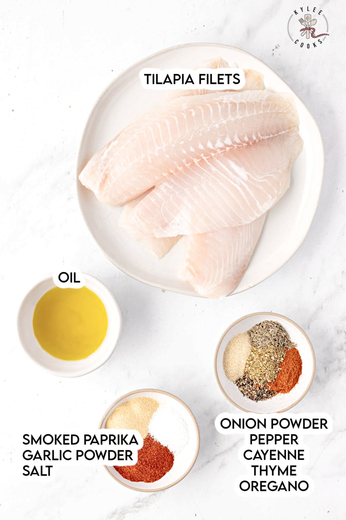 Raw tilapia fillets on a plate with small bowls of oil and spices. Text on the image says 'TILAPIA FILETS', 'OIL', 'SMOKED PAPRIKA GARLIC POWDER SALT', and 'ONION POWDER PEPPER CAYENNE THYME OREGANO'.