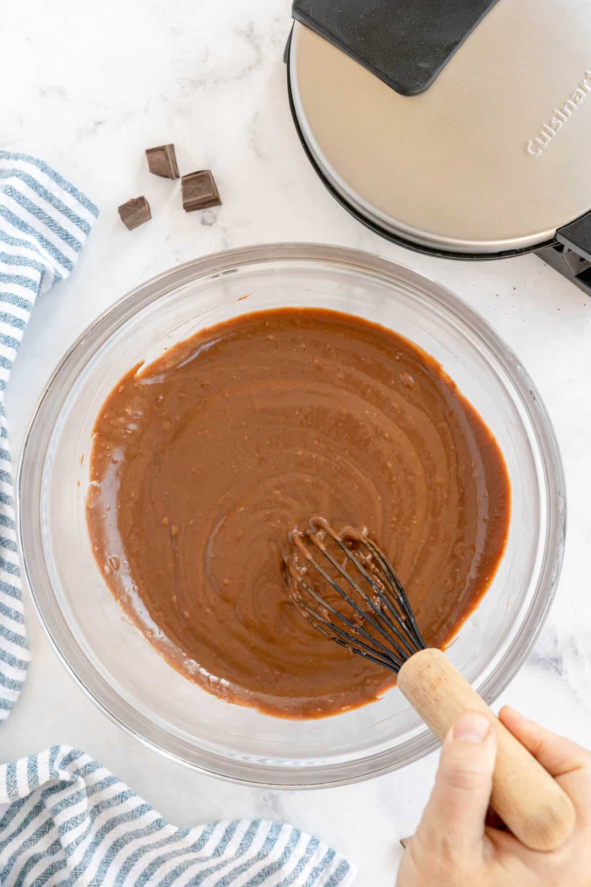 glass bowl with brownie batter and a whisk.