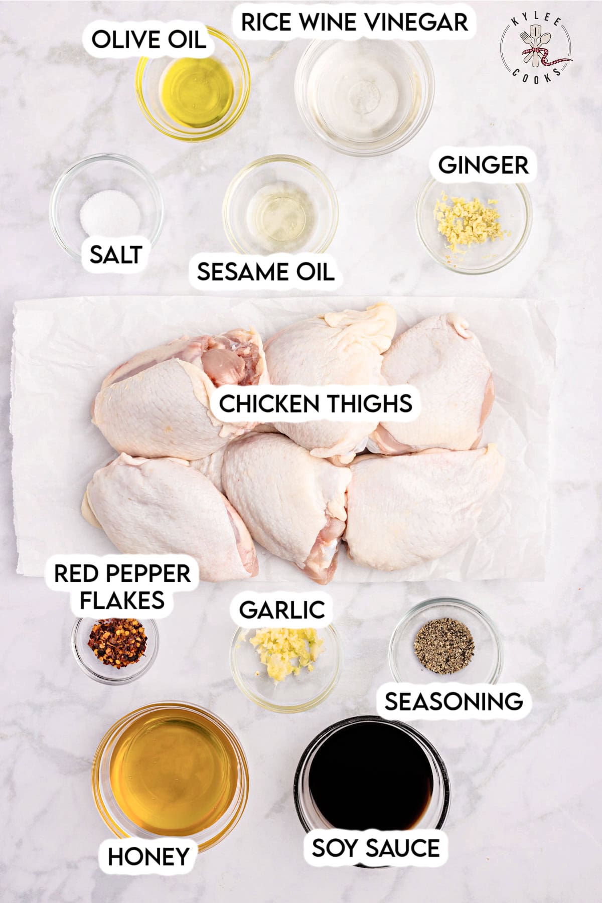 Raw chicken thighs surrounded by small bowls of olive oil, rice wine vinegar, ginger, sesame oil, salt, seasoning, soy sauce, honey, garlic, and red pepper flakes. Text on the image says 'OLIVE OIL', 'RICE WINE VINEGAR', 'GINGER', 'SESAME OIL', 'SALT', 'CHICKEN THIGHS', 'RED PEPPER FLAKES', 'GARLIC', 'SEASONING', 'HONEY', and 'SOY SAUCE'.