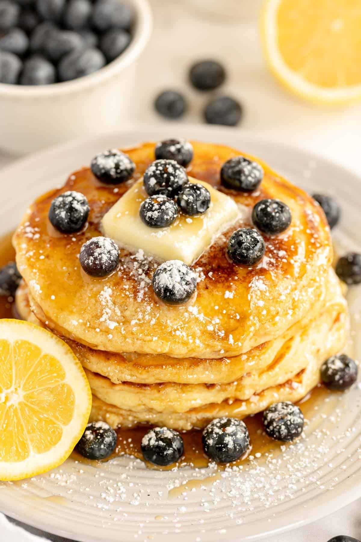 stack of pancakes with a cut lemon and blueberries.