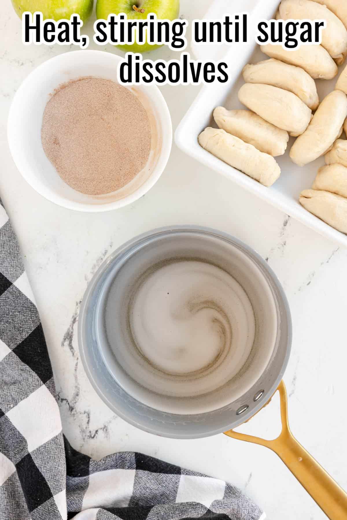 A pot of sugar dissolving on the stove, with a bowl of cinnamon sugar and a tray of dough beside it. Text on the image reads, "Heat, stirring until sugar dissolves." in the top section.