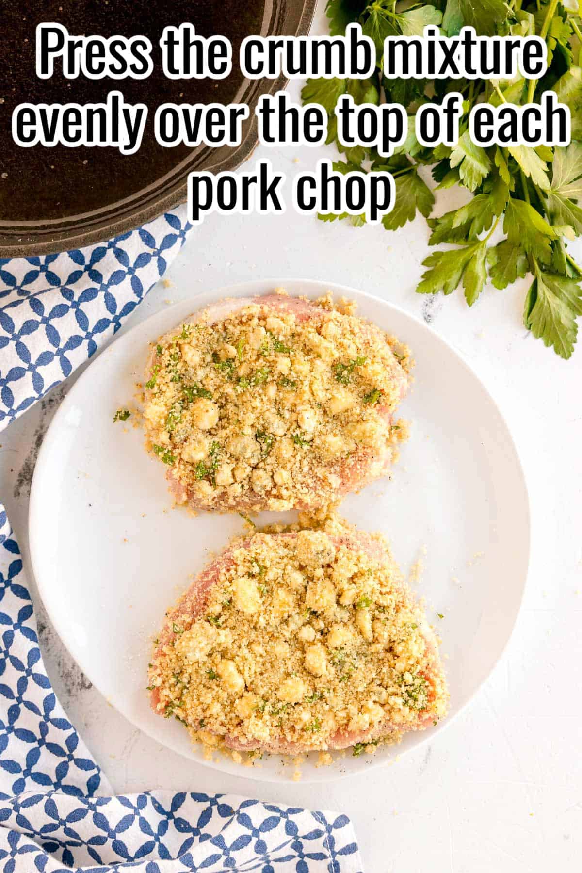 Two raw pork chops topped with crumb mixture on a plate. Text on the image says 'Press the crumb mixture evenly over the top of each pork chop'.
