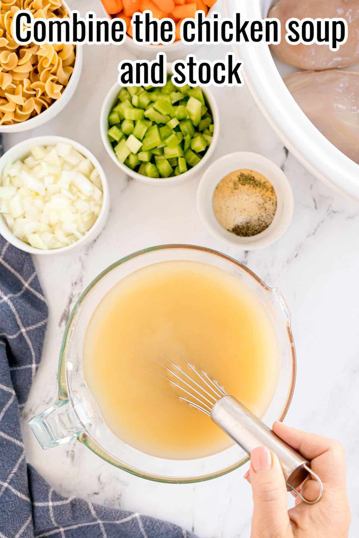 A hand whisking soup and stock in a glass measuring cup. Text on the image says 'Combine the chicken soup and stock'.