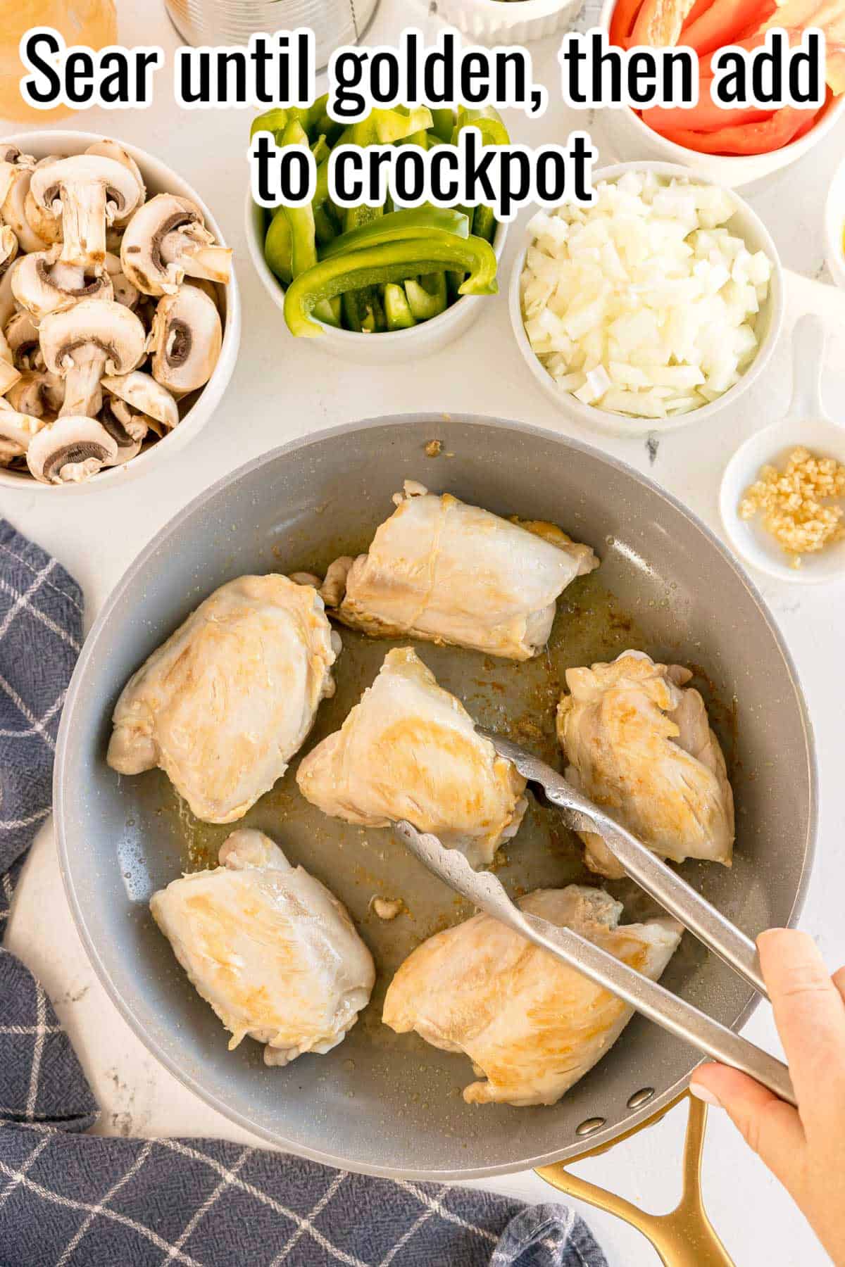 Seared chicken thighs in a skillet, golden brown on the outside, with a pair of tongs lifting one piece, and a text overlay that reads "Sear until golden, then add to crockpot."