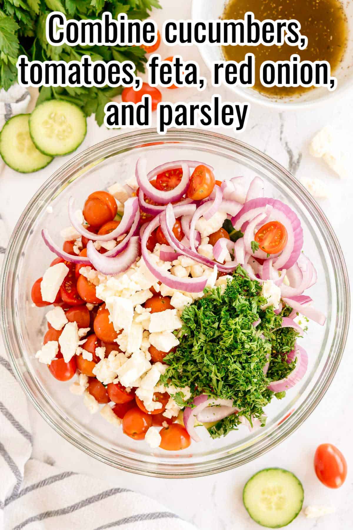 A bowl of chopped cucumbers, tomatoes, feta, red onion, and parsley. Text on the image says 'Combine cucumbers, tomatoes, feta, red onion, and parsley'.