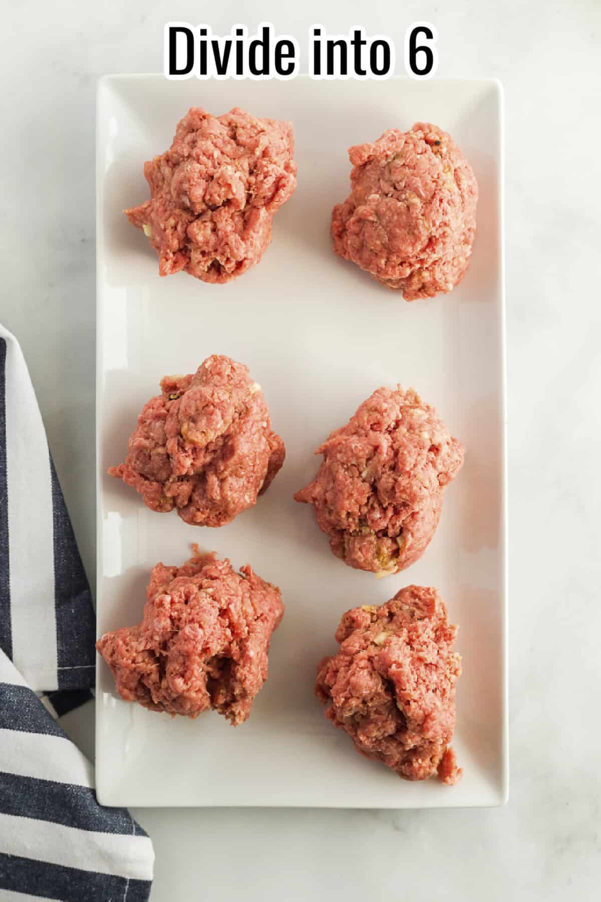 A white plate holding six portions of raw ground beef mixture, divided evenly, with text overlay reading "Divide into 6."