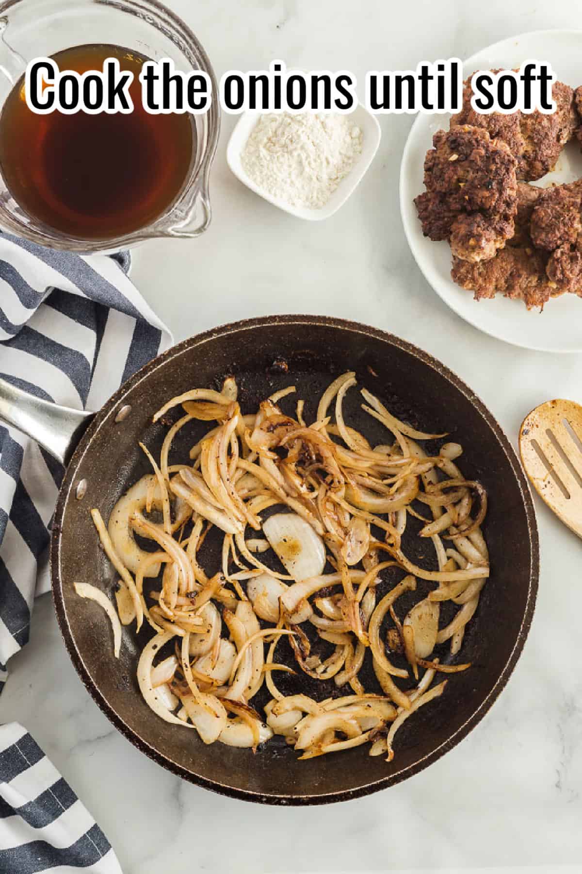 Caramelized onions cooking in a black skillet, with beef stock and flour nearby, with text overlay reading "Cook the onions until soft."