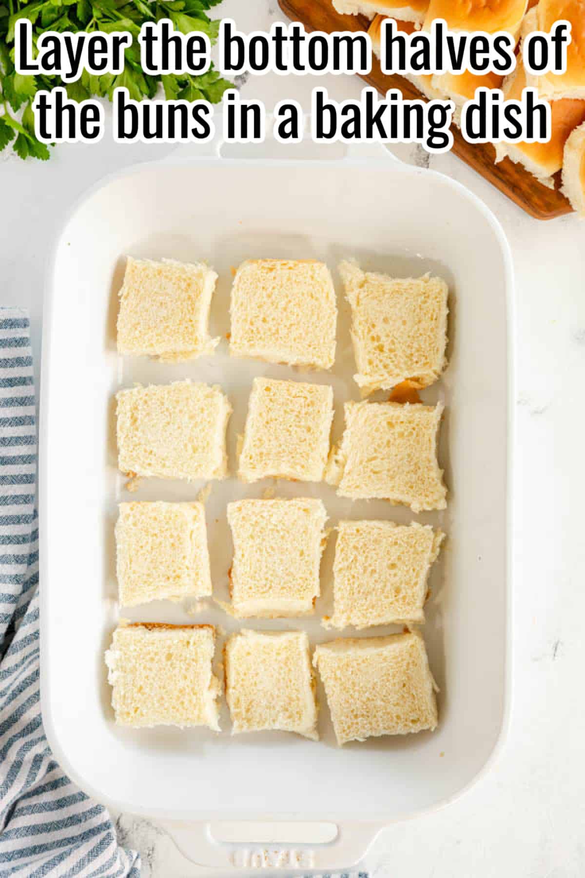 Layer the bottom halves of the ham and cheese sliders buns in a baking dish.