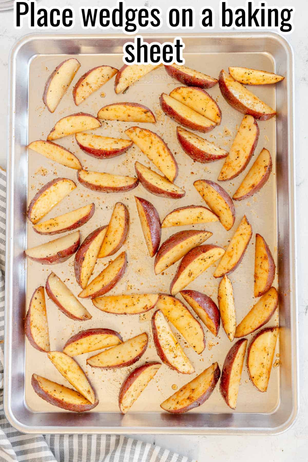 Seasoned potato wedges arranged on a baking sheet. Text on the image says 'Place wedges on a baking sheet'