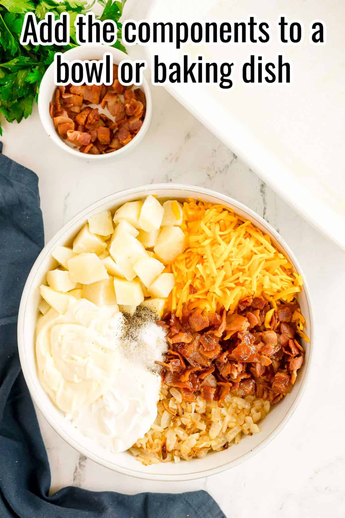 A large bowl filled with potatoes, cheddar, bacon, sautéed onions, sour cream, mayo, and seasonings. Text on the image says 'Add the components to a bowl or baking dish'.