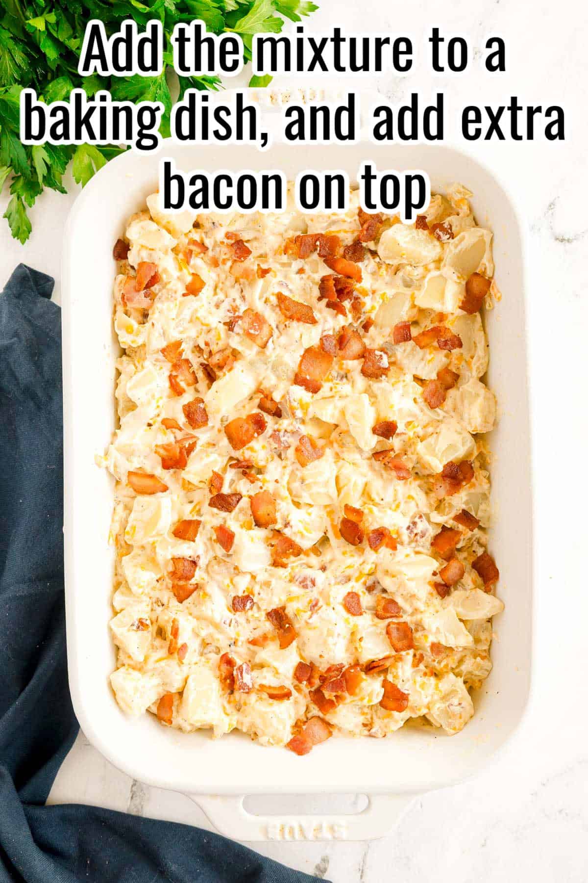 The potato mixture spread in a white baking dish and topped with extra bacon. Text on the image says 'Add the mixture to a baking dish, and add extra bacon on top'.