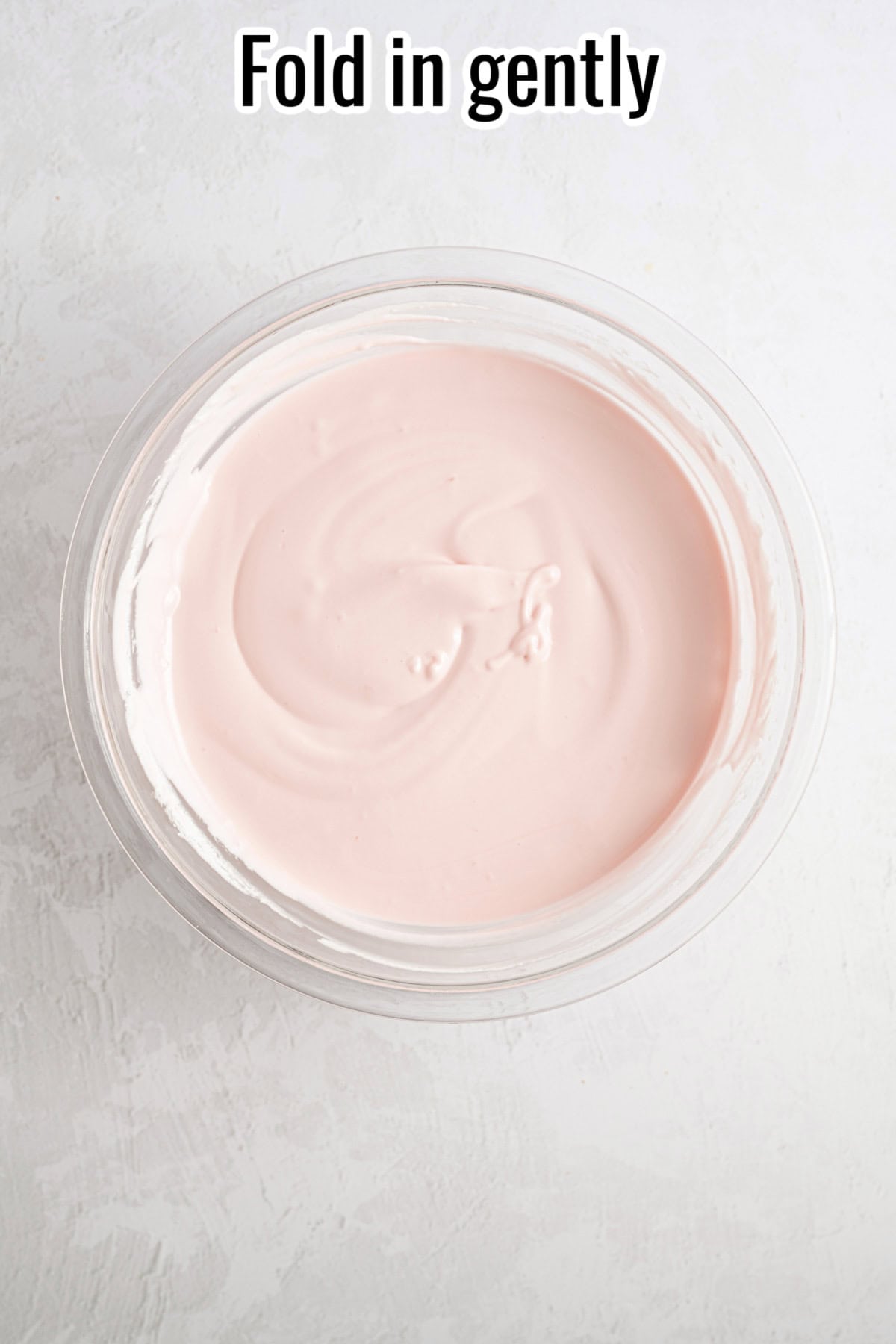 A bowl with smooth, pale pink filling. Text on the image says 'Fold in gently'.