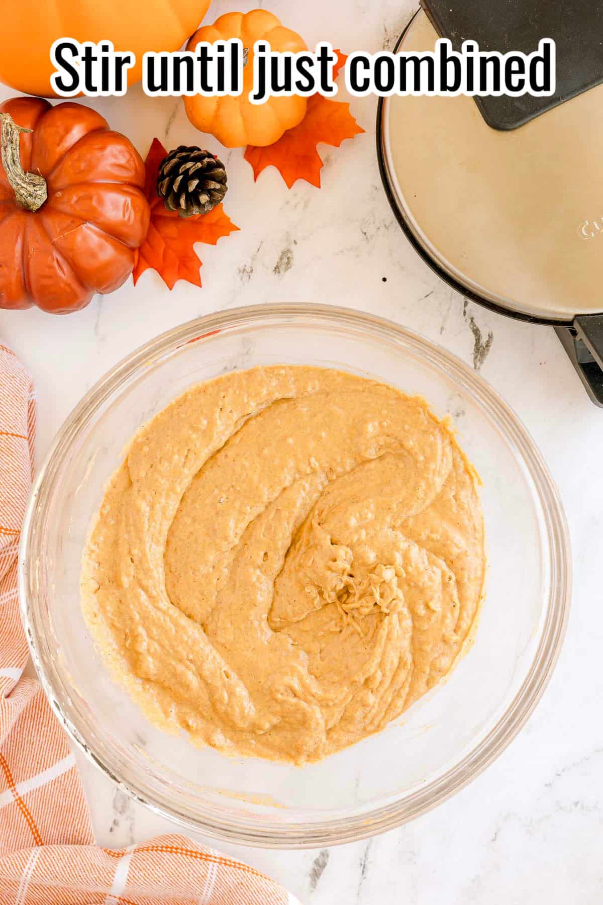 A bowl of pumpkin waffle batter. Text on the image says 'Stir until just combined'.