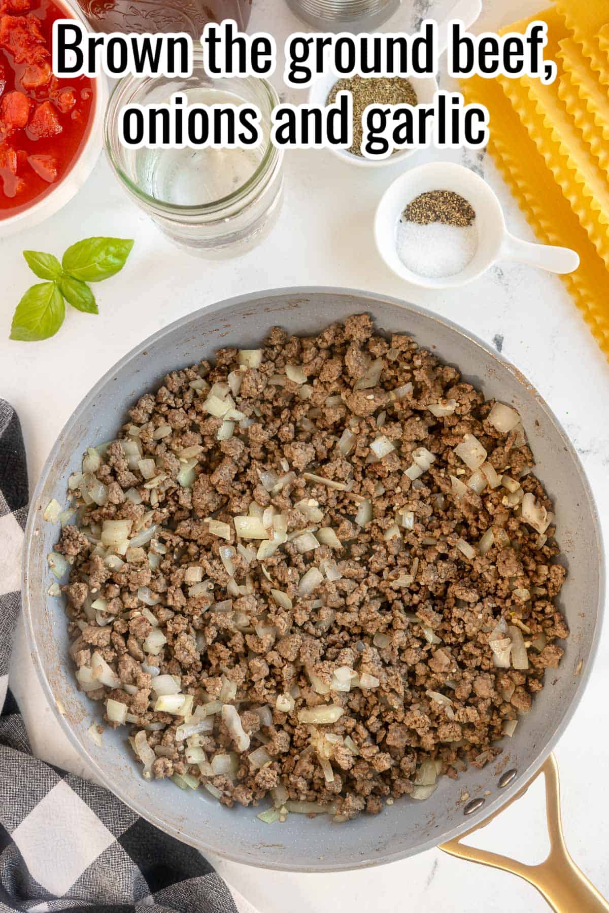 A skillet with browned beef, onions and garlic.