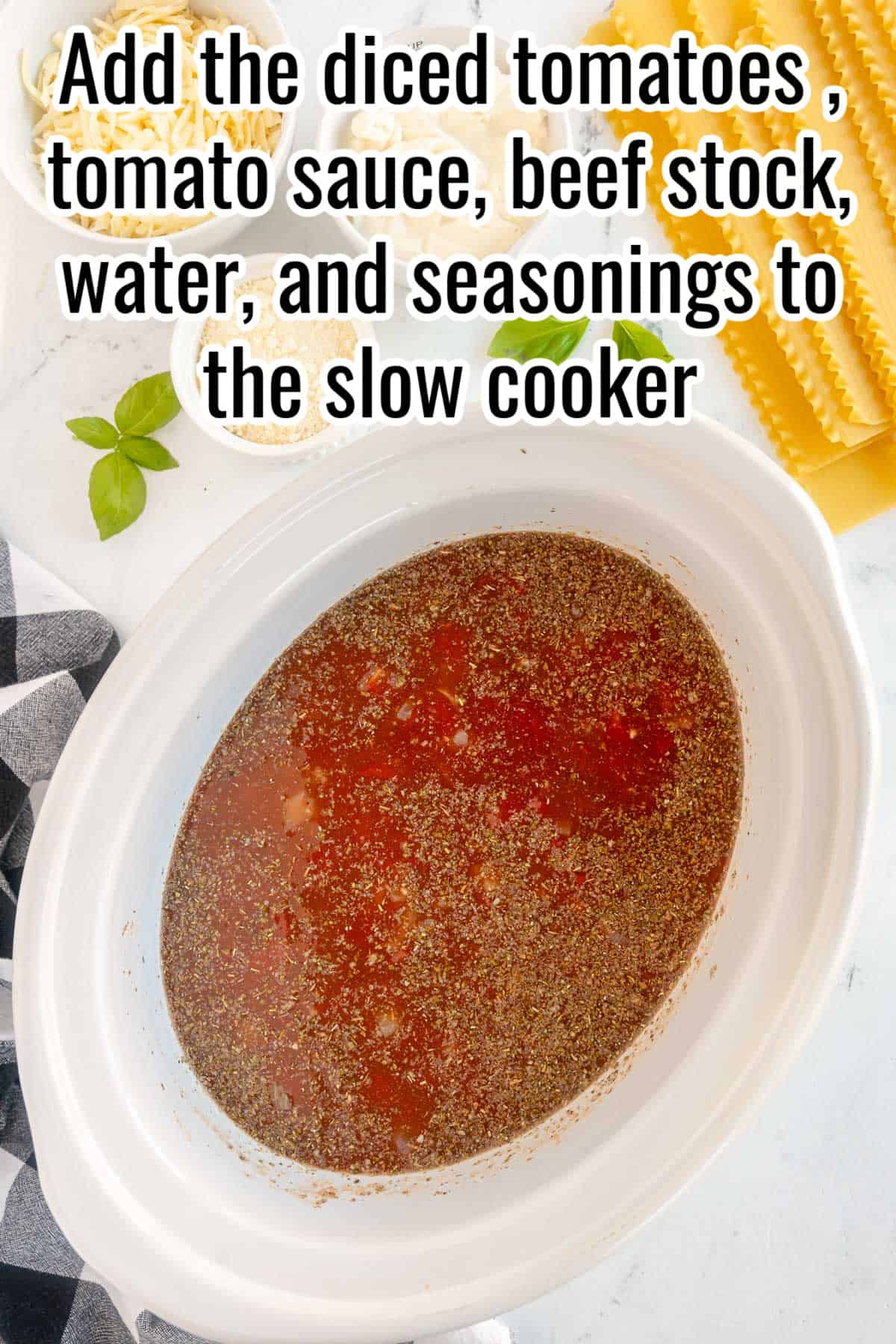 A slow cooker with uncooked lasagna soup base.