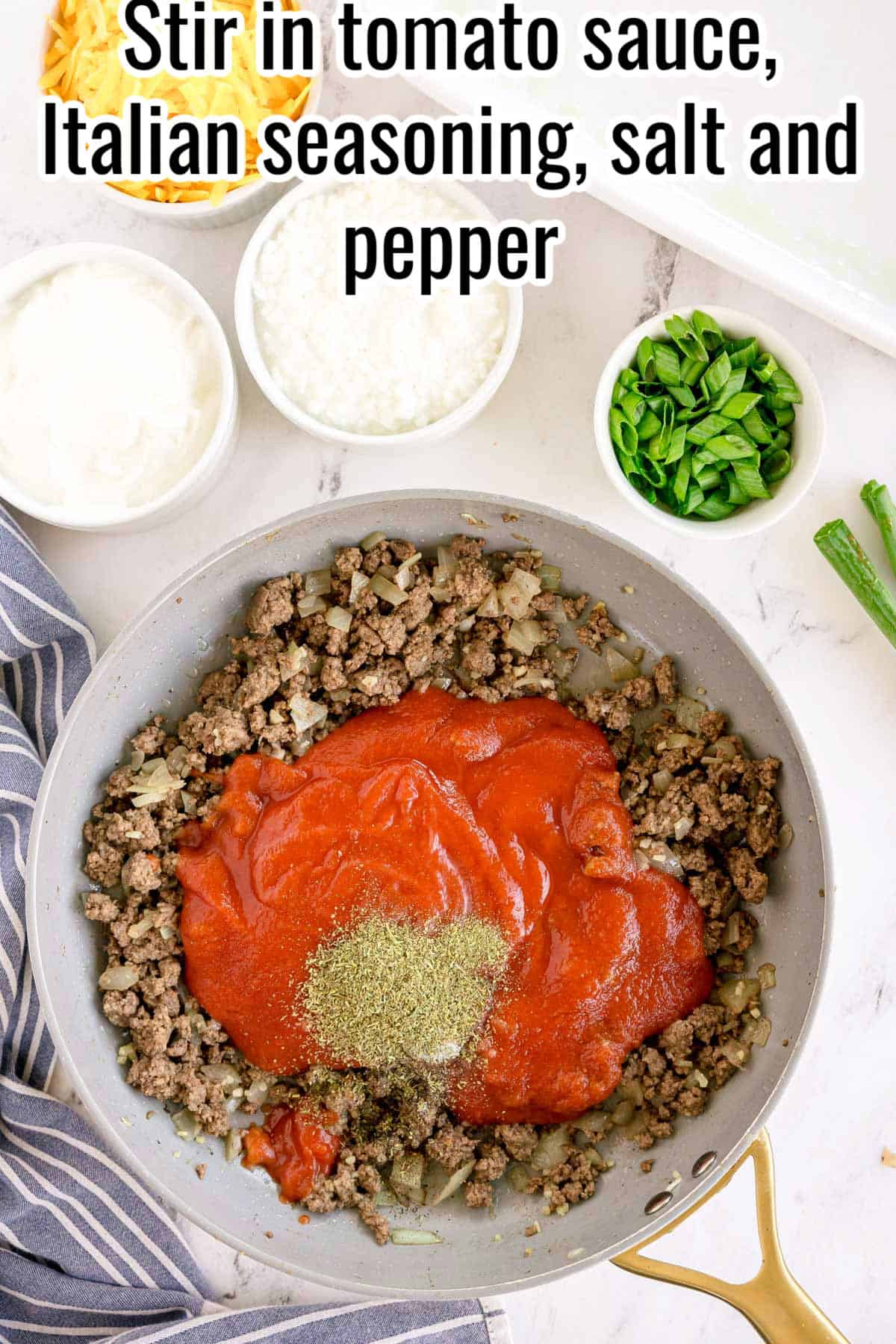 A skillet with tomato sauce and seasonings on top of cooked beef and onions. Text on the image says 'Stir in tomato sauce, Italian seasoning, salt and pepper'
